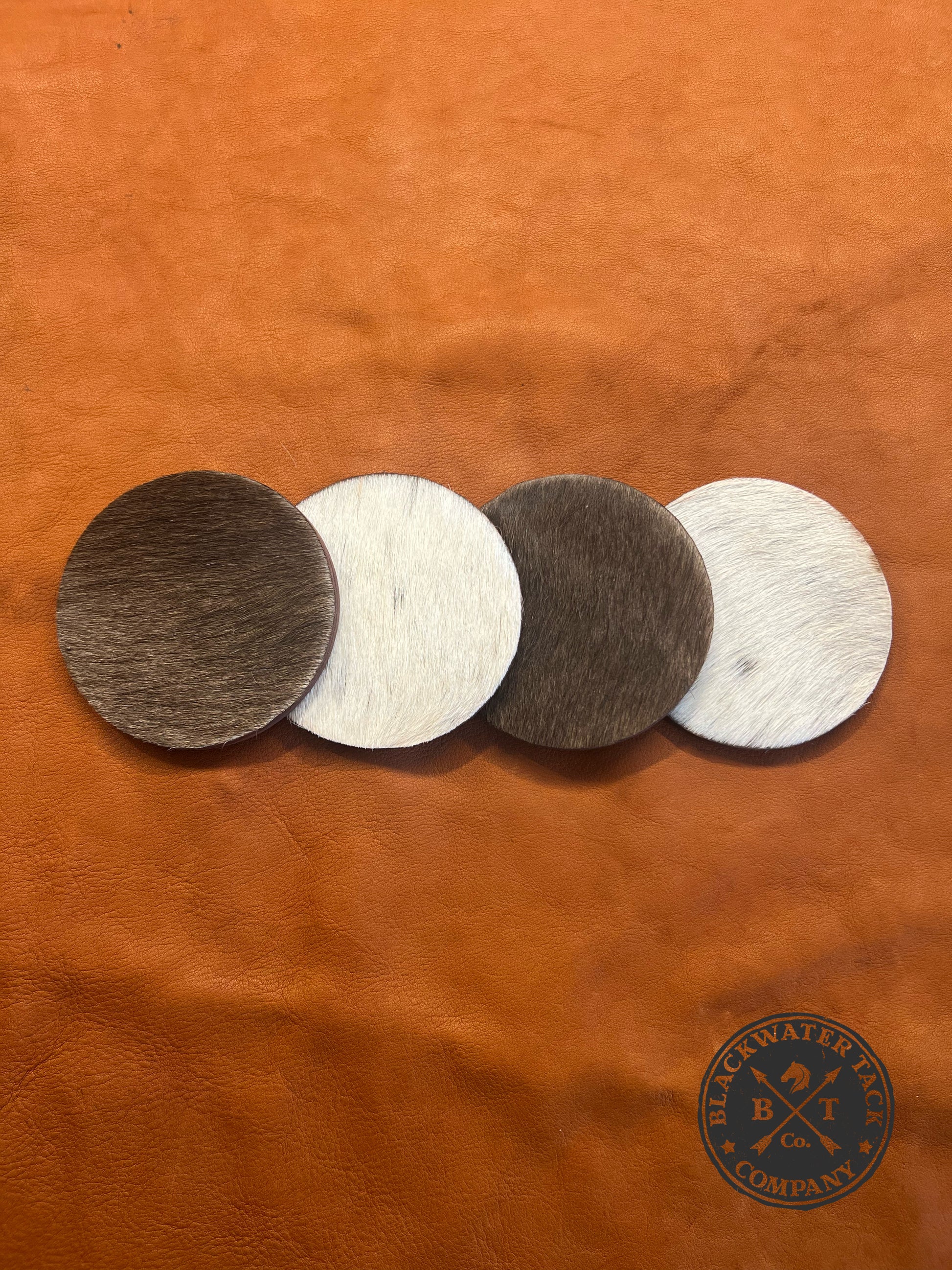 coasters with hair-on-hide cow leather stitched on the top