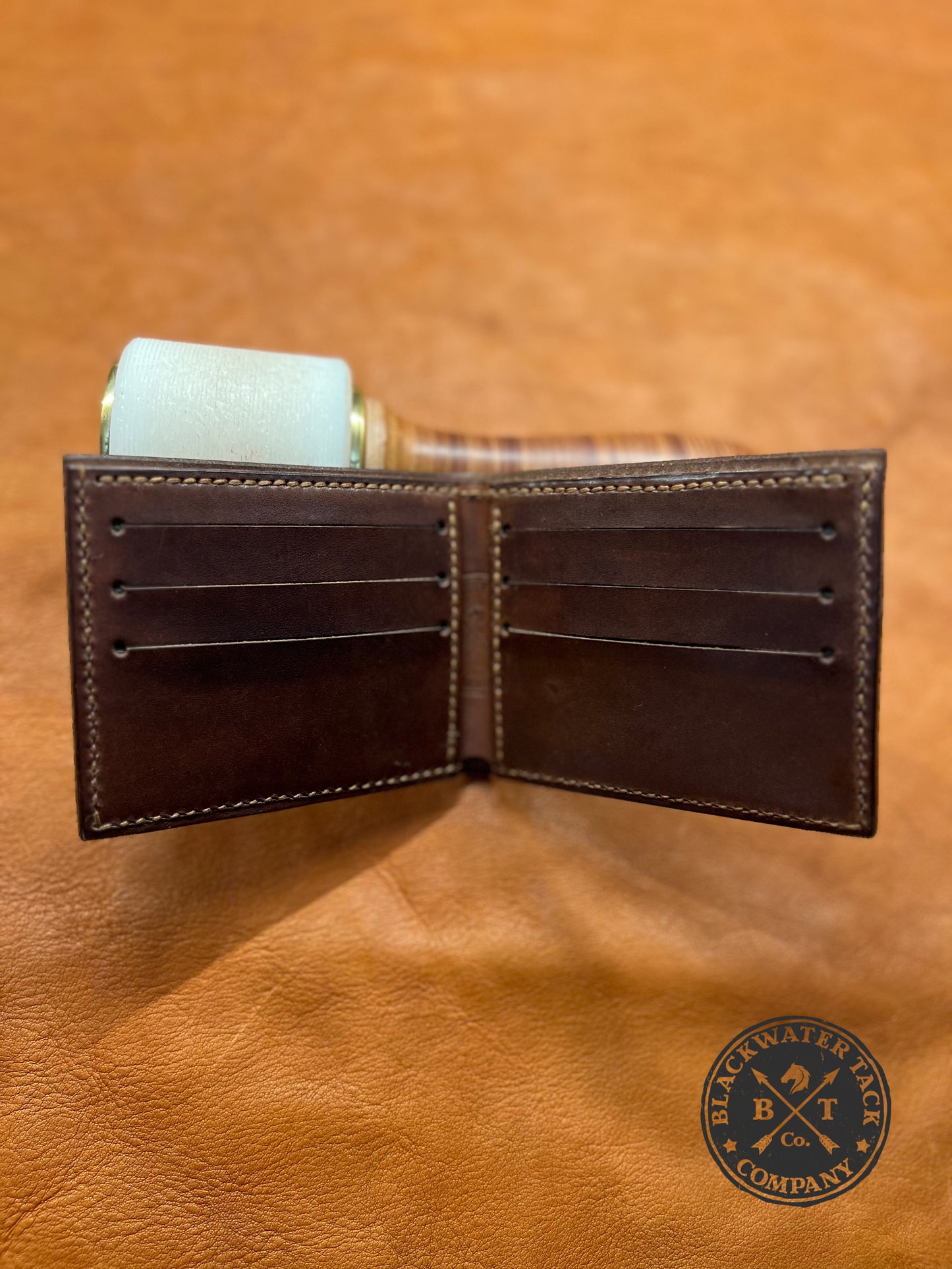 an open brown bi-fold wallet showcasing the six card slots