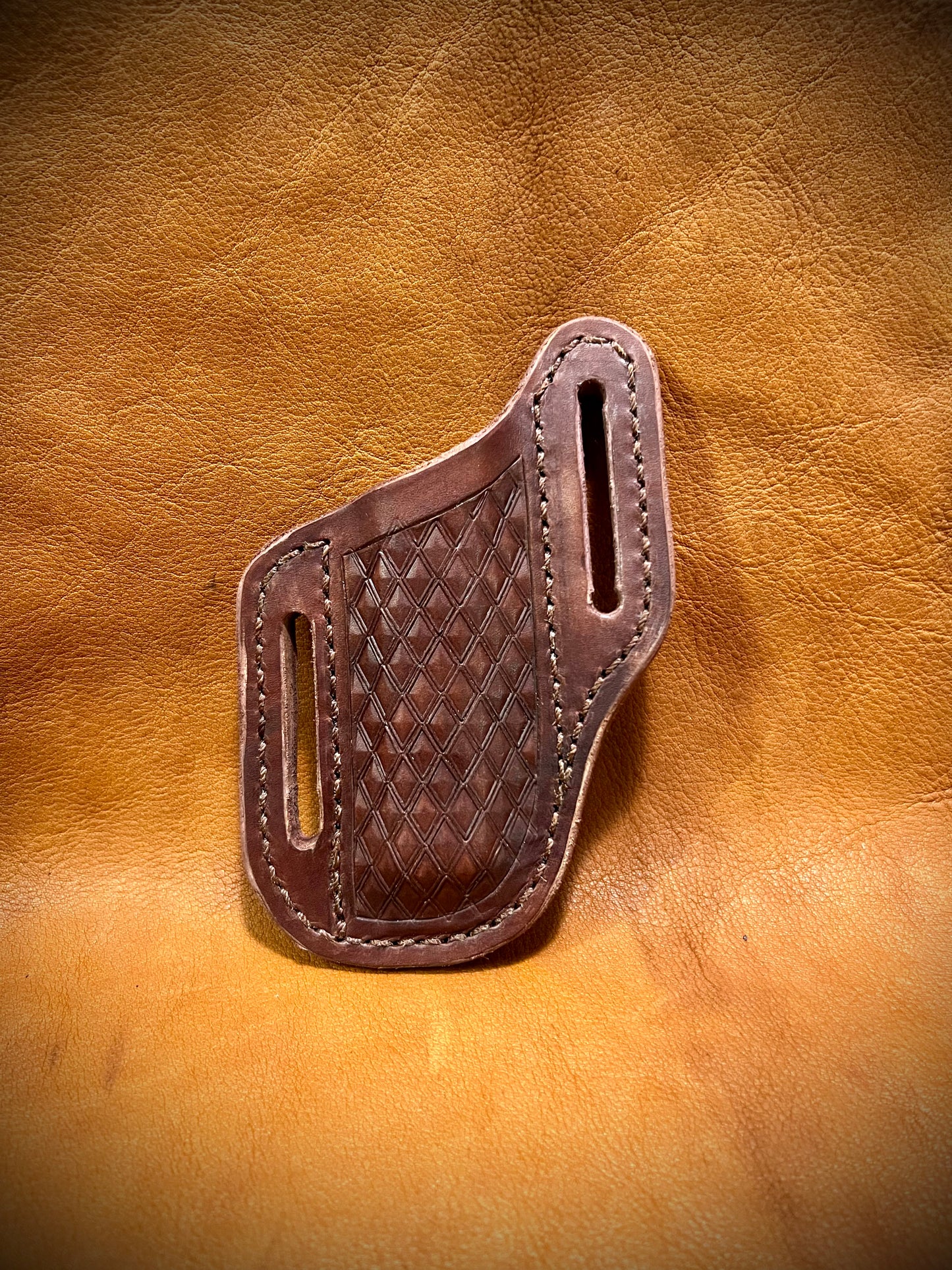 A trapper style knife sheath with a diamond pattern on the front.