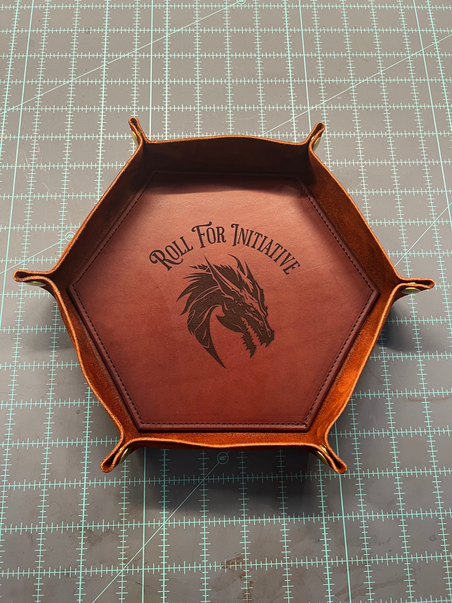 a mahogany colored valet tray with roll for initiative and a dragon engraved inside