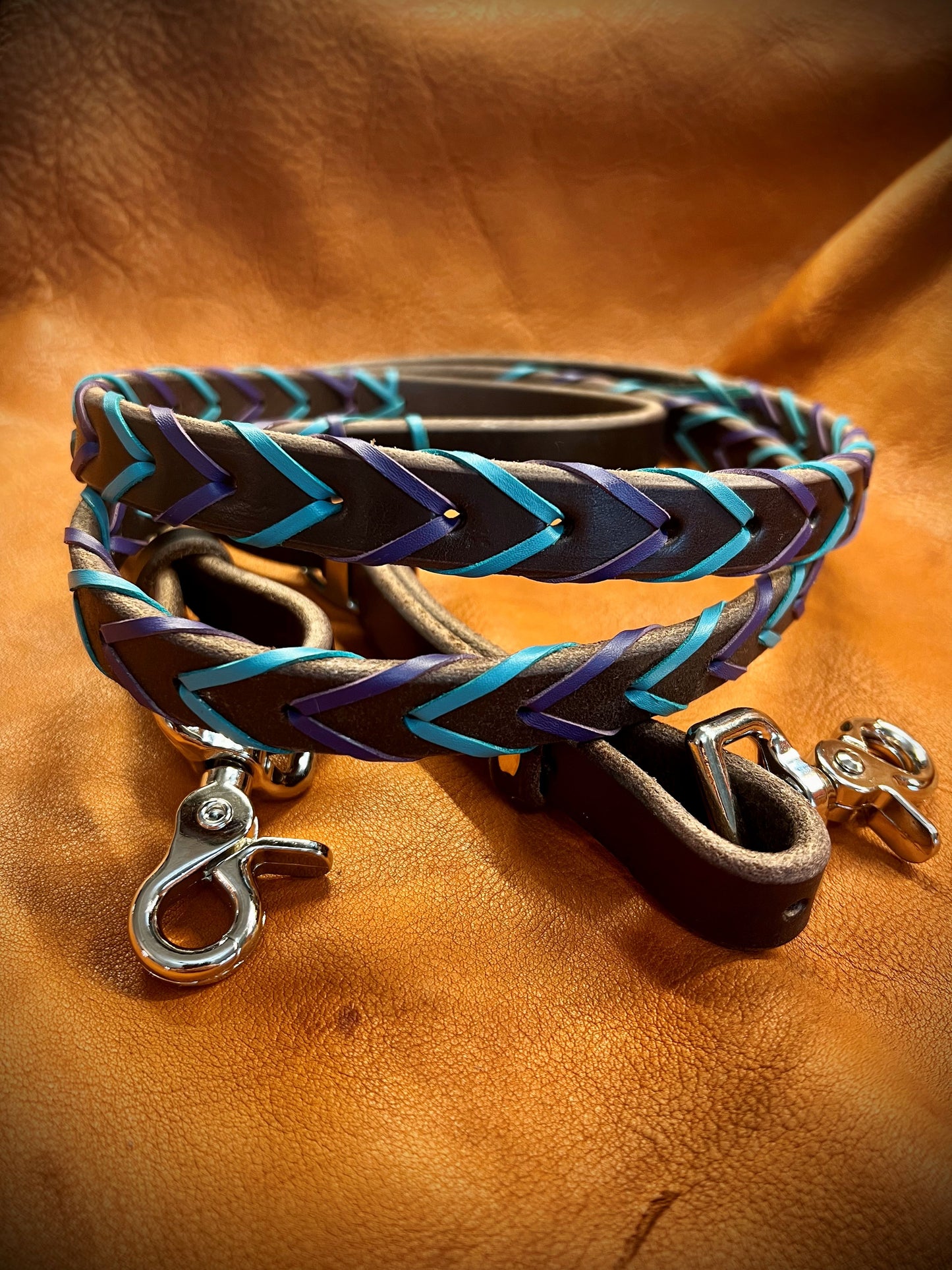 a set of laced reins with purple and turquoise lace