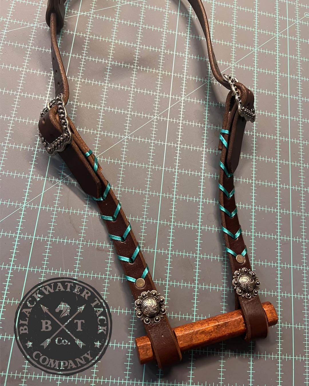 a close up of a one-ear headstall with metallic turquoise kangaroo lace